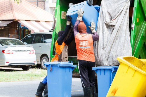 Workers preparing for garden clearance with protective gear and tools